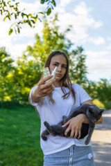 Fototapeta premium Woman holding a cat. Woman is allergic to cats. Allergy to cat fur.