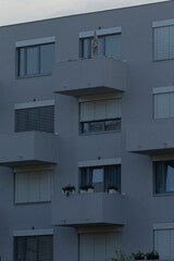A modern apartment building featuring sleek balconies adorned with greenery, showcasing urban living at its finest.