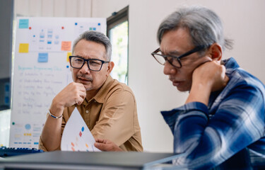 Group of asian senior in a collaborative software development analyzing  flowcharts  during a bootcamp training
