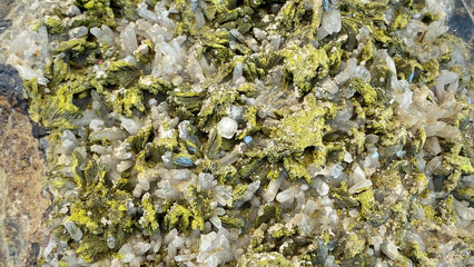 A unique mineral, close-up. An exquisite rare geological specimen. Perhaps it is epidote combined with quartz. An exhibit from a tourist center in Gobustan