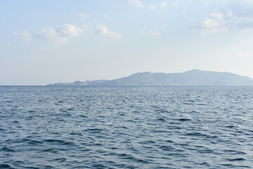 Obraz premium Panorama of Rhodes Island from the sea. Beautiful sea landscape. Holidays and travel to Greece. Motorboating during vacation. Boat rental. Summer vacation at sea. Tourist boat trip. 