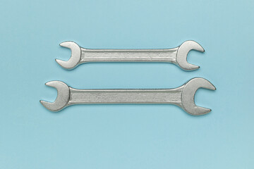 Minimalist Design of Two Metal Wrenches on Soft Blue Background