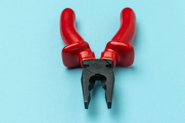 Red Handled Pliers on Blue Background: Essential Tool for DIY and Construction Projects
