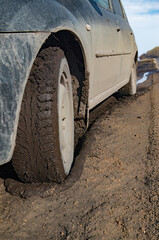 Mud-covered vehicle stuck on a rural dirt road © Alexander