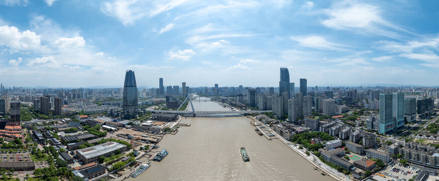 An expansive city skyline featuring tall buildings and a wide river shows the urban landscape of Ningbo, China under a bright sky.