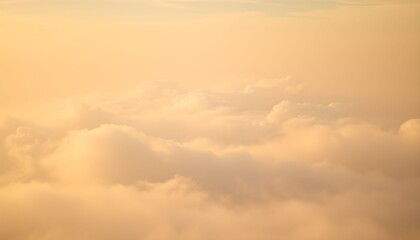 Obraz premium Golden sunset light illuminates a vast expanse of fluffy clouds viewed from above.