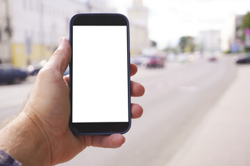 Man holding smartphone with white screen in city street