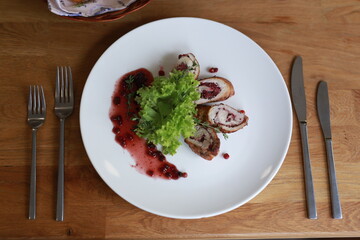 Delicious Fried Roulade Garnished with Lettuce and Berries on White Plate