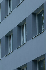 A close-up view of a contemporary building facade featuring a repetitive and symmetrical arrangement of windows.