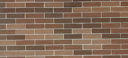 Obraz premium A brick wall with a brown color. The wall is made of bricks and has a rough texture