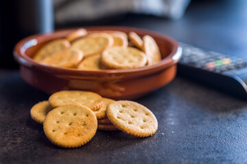 Crispy round salted crackers on black table.