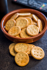 Crispy round salted crackers on black table.