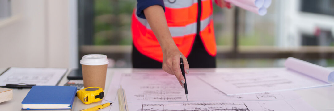 Architect professional reviews detailed construction blueprints planning future building projects ensuring precise design implementation at office workspace