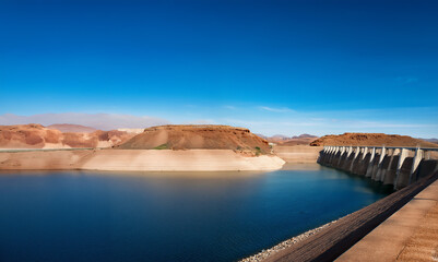 Man-made reservoir, with low water level, highlighting the issue of water shortage due to climate change and irrigation.