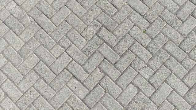 High-resolution photo of an interlocking paving block pattern, ideal for urban design backgrounds, construction presentations, or real estate marketing. Its symmetrical, clean texture fits architectur