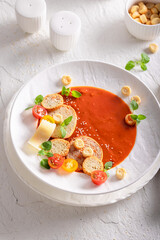 Refined tomato soup with high-end presentation on plate.