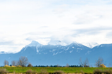 Obraz premium View of rural canada on Highway from Abbotsford to Hope, BC, Canada with mountains, valleys and farms in the background