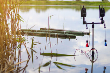 Professional carp fishing bite alarms from lakeside background. Carp fishing background. Carp fishing photo collection. Fishing rods for carp with signaling devices on the holder. Fisherman's Day. 