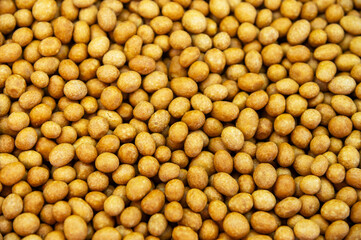 Close-up of delicious peanuts roasted in coconut glaze. Many are lying on the plane