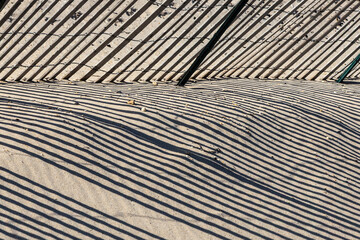 fence at the beach gives a harmonic shadow in morning light