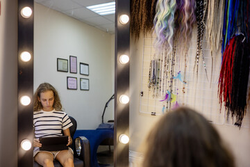 Preparing for a creative makeover in a stylish salon with vibrant hair accessories and thoughtful reflection