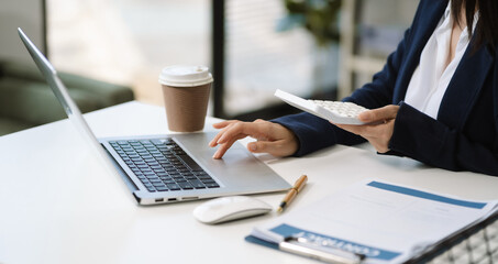 Business woman calculates financials with graph paper on the table on the cost.