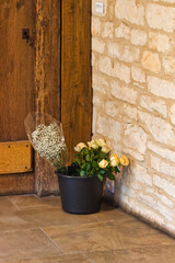 Blumenstrauß vor Holztür und Steinwand