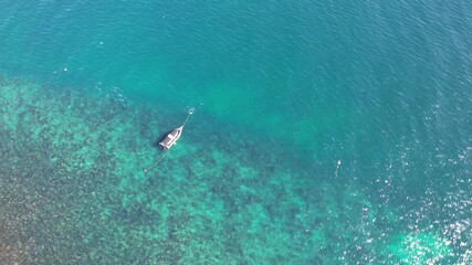 Aerial drone view of a small snorkelling tourist boat passing anchored off Cook Island nature reserve and Fingal Head causeway, New South Wales, Australia