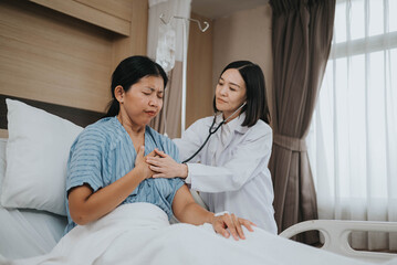 Obraz premium Asian doctor using stethoscope and talking with patient to checkup in hospital room. Health care concept.