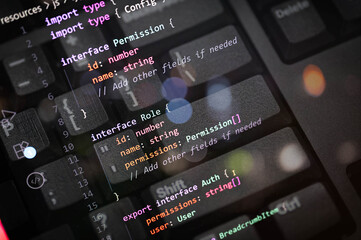 TypeScript code interface for user role and permission authentication on keyboard background, illustrating secure backend development, data access control, and API structure.