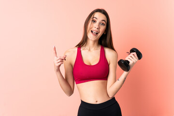 Young sport woman making weightlifting over isolated pink background pointing up a great idea