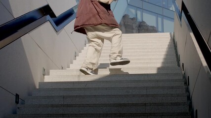 A dynamic scene captures diverse movements in an urban setting a person walks up stairs, another skates down, and a man sprints upward. A final individual descends, showcasing agility