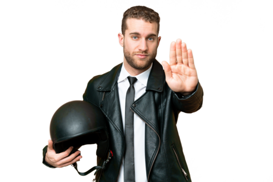 Business man with a motorcycle helmet over isolated chroma key background making stop gesture