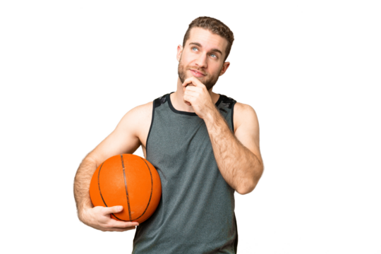 Handsome young man playing basketball over isolated chroma key background and looking up