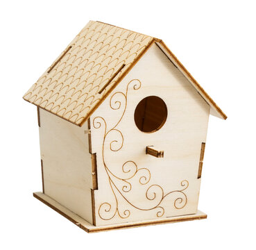 Side view of an empty wooden birdhouse with decorative swirls standing on white background