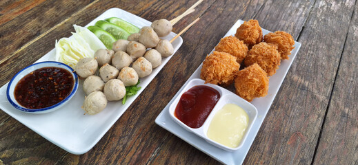 Cheese balls, mozzarella croquettes fried, breaded fast food with sauce and  grilled meatballs with wooden table background