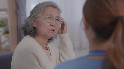 Young Asian female care nurse gives advice to elderly woman health problems. Male doctor consulting patient, clinic room for medical care, getting health advice, discussing treatment plan, explaining - Powered by Adobe