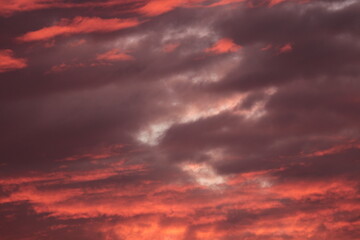 Ominous Dramatic Apocalyptic Sky Background. Dark Scary Sunset with Storm Clouds Illuminated by Eerie Red and Pink Light. Concept of Doom, Threat and Climate Change.