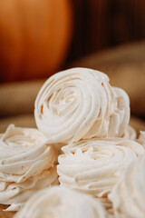 Homemade pumpkin marshmallows on rustic wooden table with seeds and autumn decor
