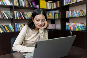 Teenage school girl working on a computer in the library