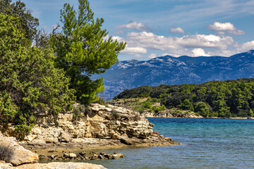 Azure water in the Adriatic Sea, rocky coast of the island of Rab, cloudy, threatening sky, Strucic...