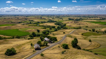 Obraz premium A picturesque view of rolling hills and farmland under a clear blue sky.