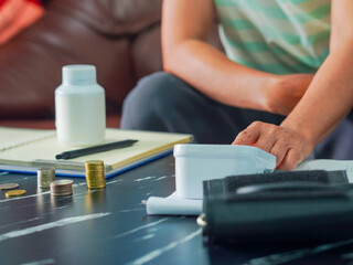 Senior woman is taking notes retirement savings and health care expenses. Retired senior is planning health care and finances, life planning. Elderly care female note and check medicine. Lifestyle 