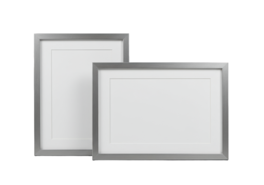 Two empty, sleek silver-grey metallic picture frames side-by-side, with a white mat board leaning, against a transparent background, bright high-key studio lighting, commercial product display concept