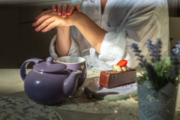 Elegant matured woman enjoying calm morning ritual with pastry and tea in serene desert setting, embracing joy and tranquility during menopause journey