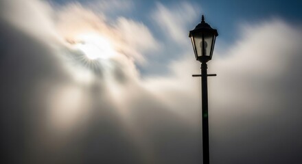 Silhouetted streetlamp against dramatic cloudy sky at sunset