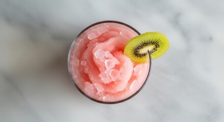 Refreshing pink slush with kiwi garnish on marble surface