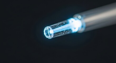 Close-up of glowing fiber optic cable with blue light emission