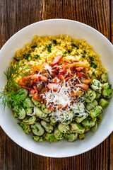 Boiled broad beans with bulgur, fried bacon and onion on wooden table	
