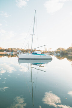 A yacht on the Clarence River at Yamba with reflection in the clear water below